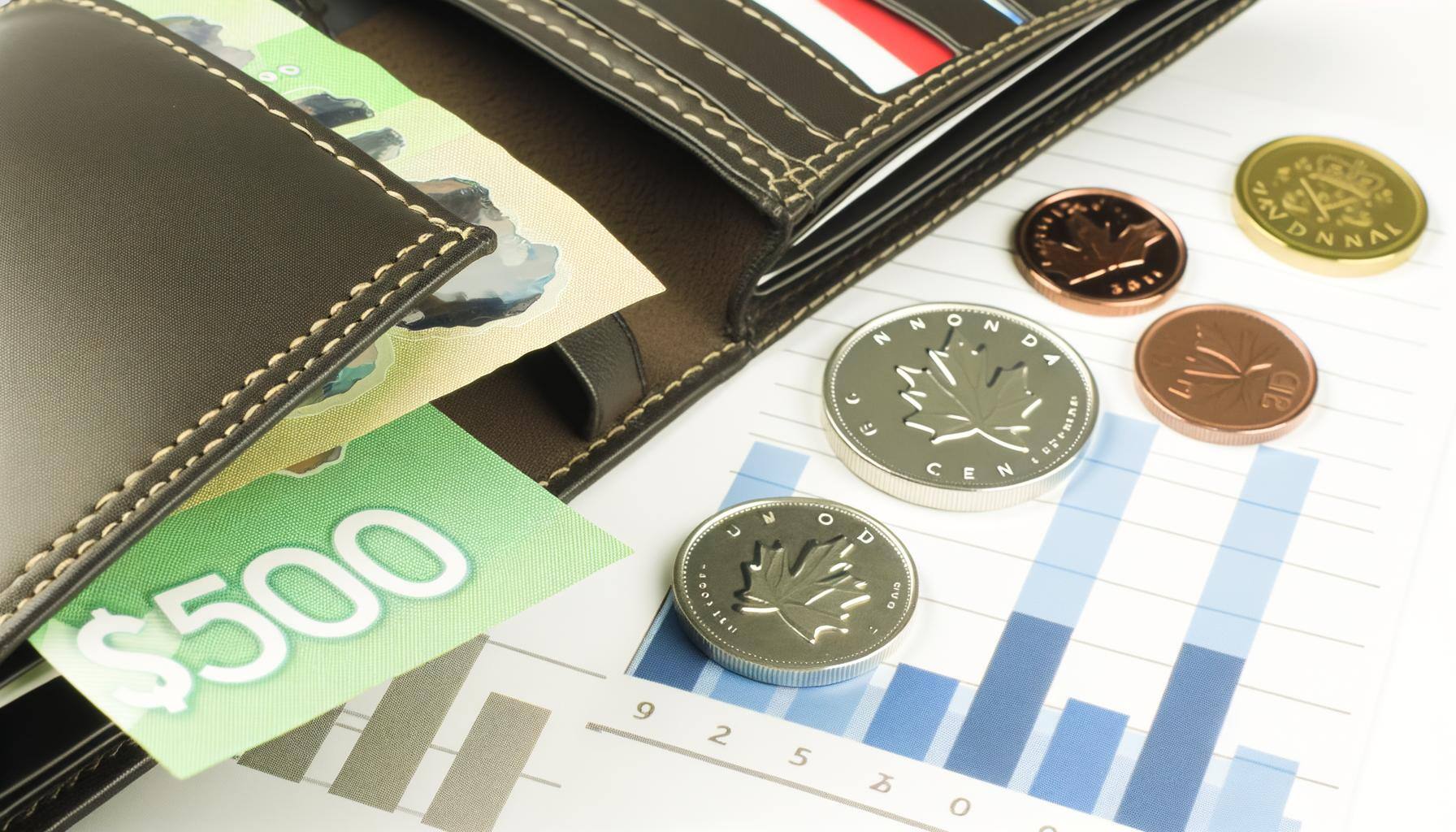 Un portefeuille ouvert avec des billets et des pièces canadiennes, posé à côté dun carnet de budget avec des graphiques ou des icônes financiers en a